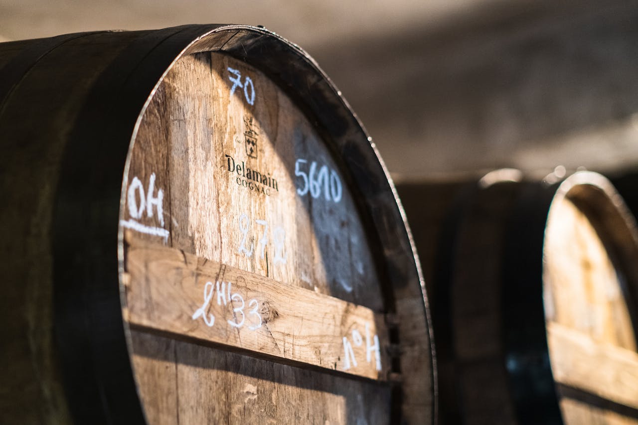 Detailed close-up of wooden wine barrels in a cellar in Cognac, France.
